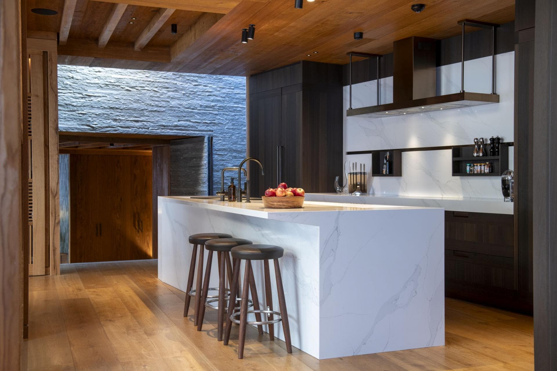 Kitchen island with waterfall marble counter and seating for three