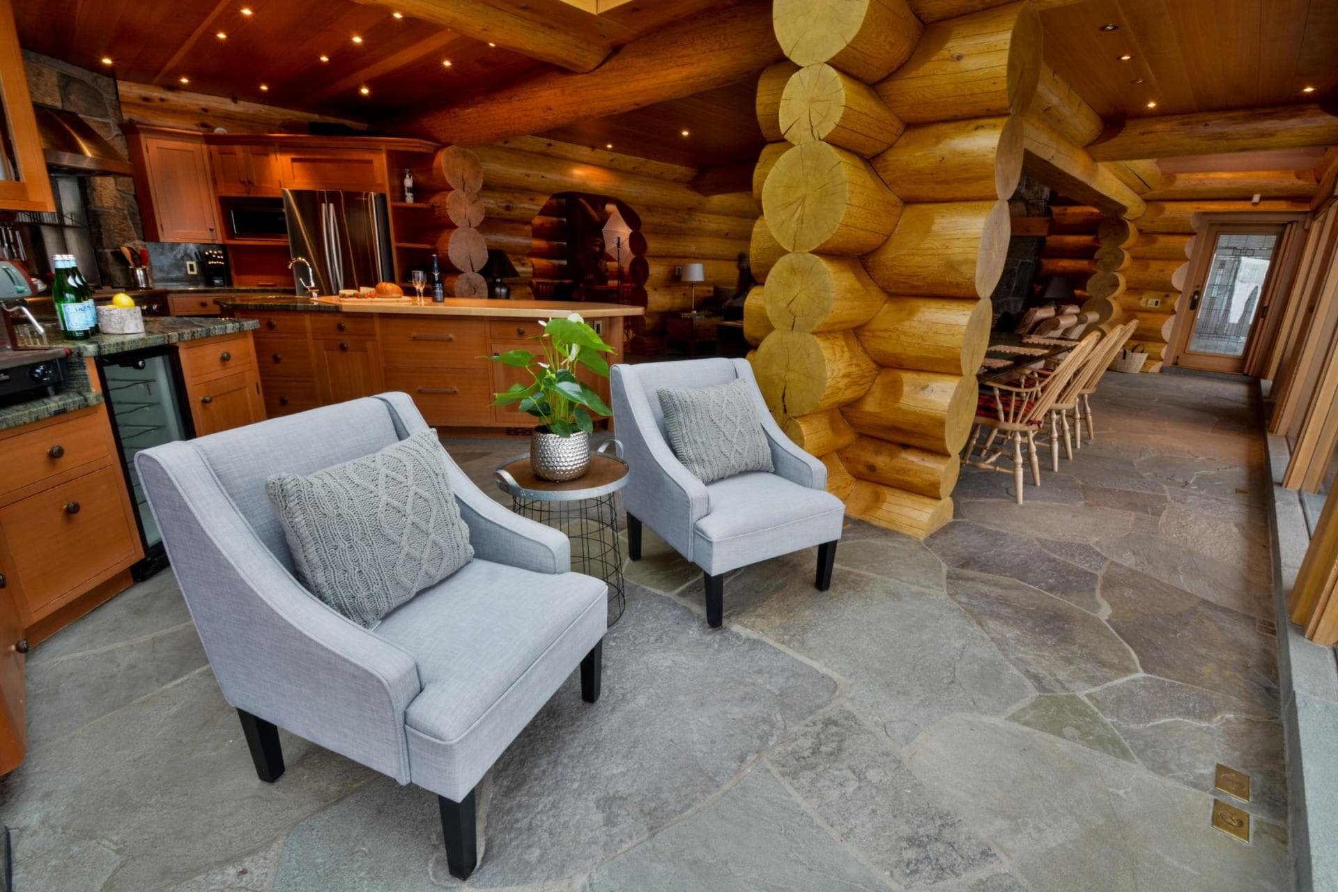 Open-plan kitchen and living area with flagstone flooring and wine fridge