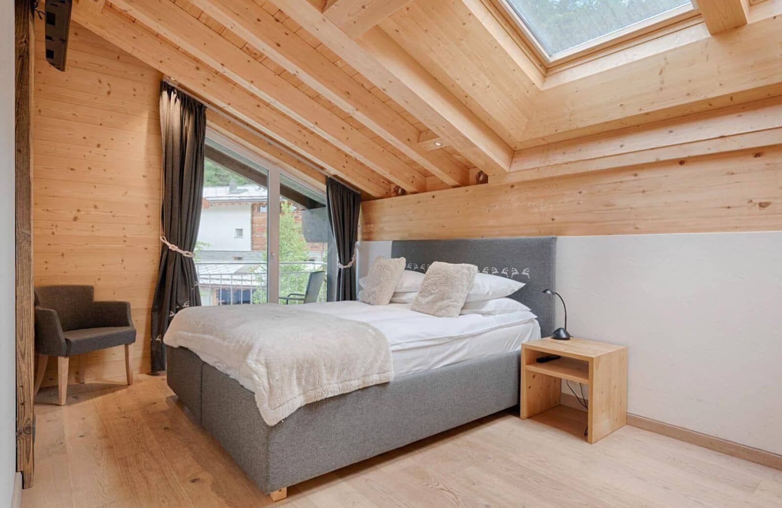 Attic bedroom with queen bed, skylight, and private balcony access