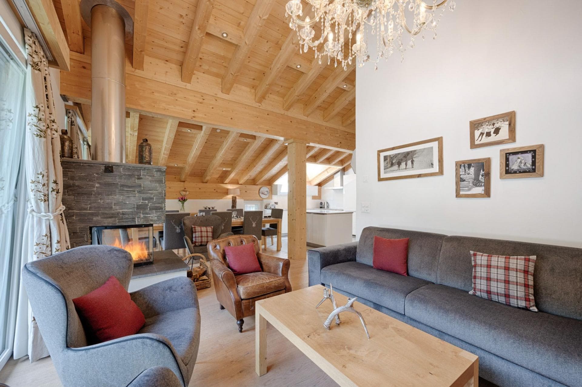 Open-plan living area with wood-burning fireplace and vaulted timber ceilings
