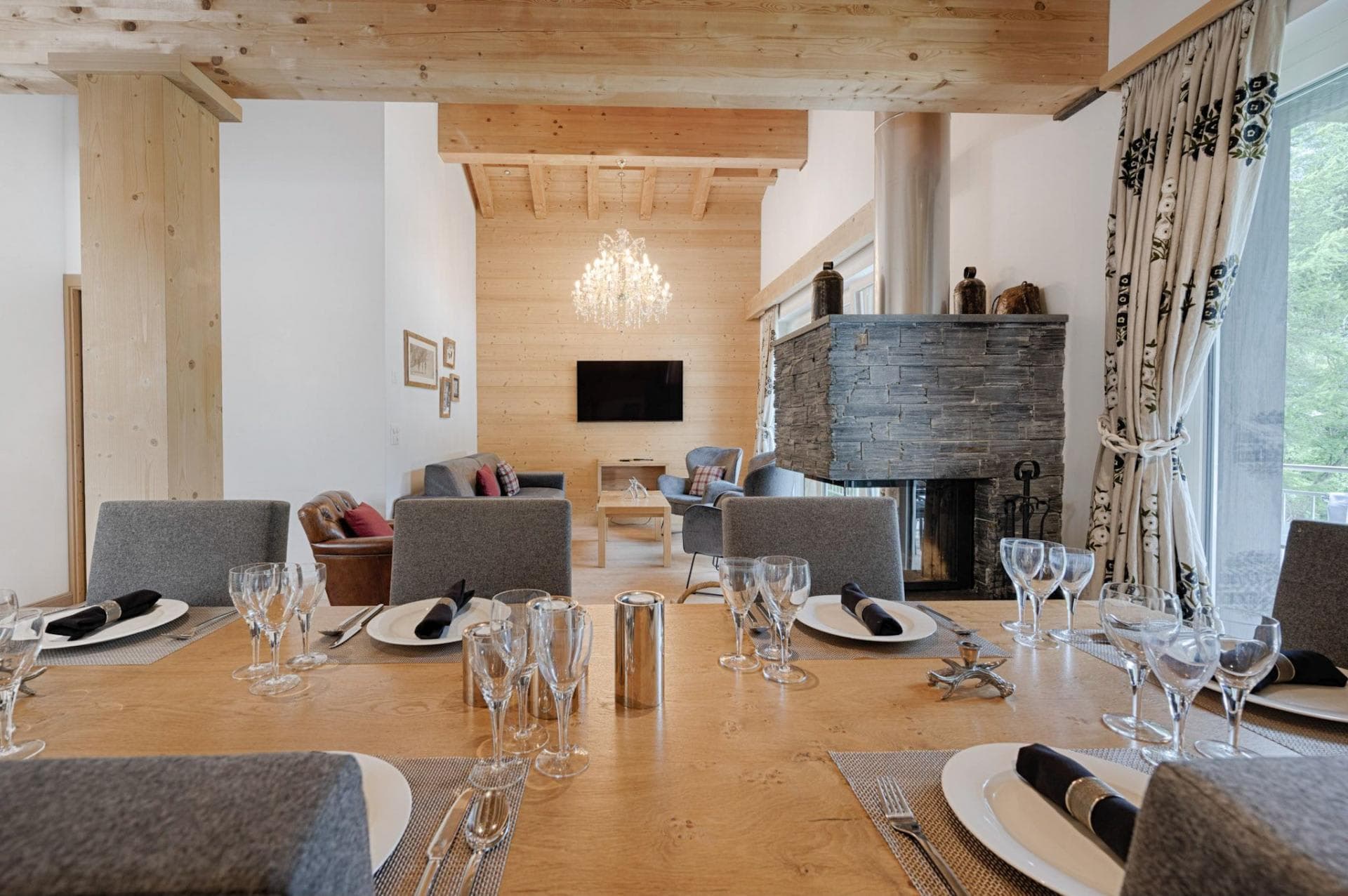 Open-plan dining area and living room with double-sided stone fireplace