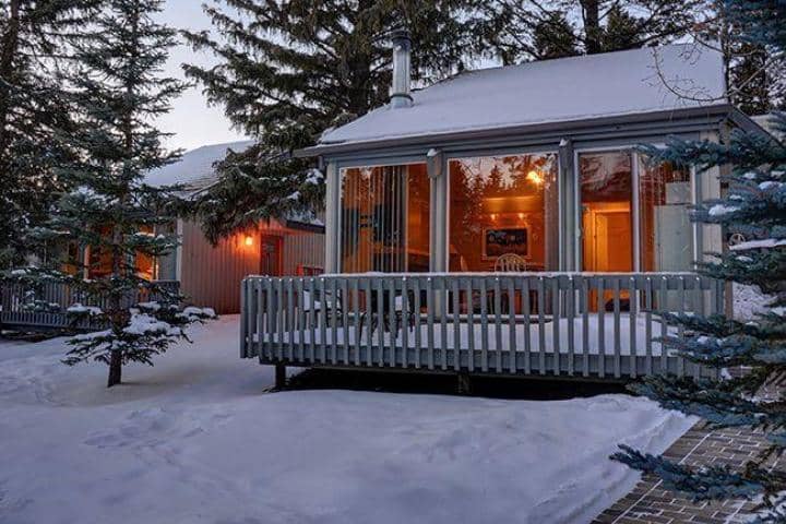 Cabin exterior with private snow-covered deck and floor-to-ceiling windows