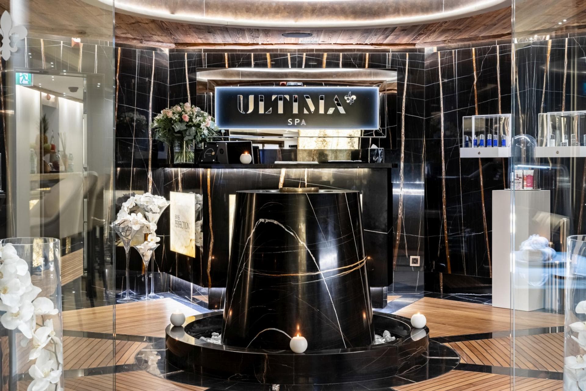 Ultima Spa reception with black marble and wood accents