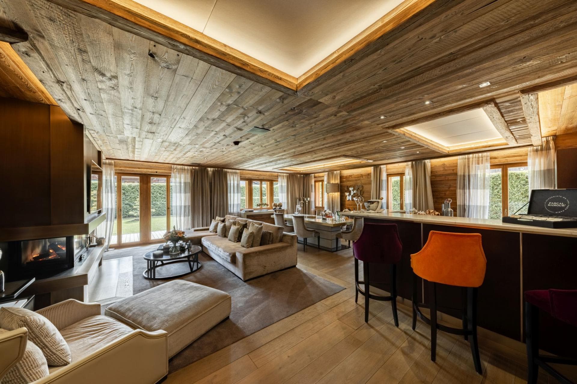 Open-plan living area with wood-clad ceilings and wood-burning fireplace