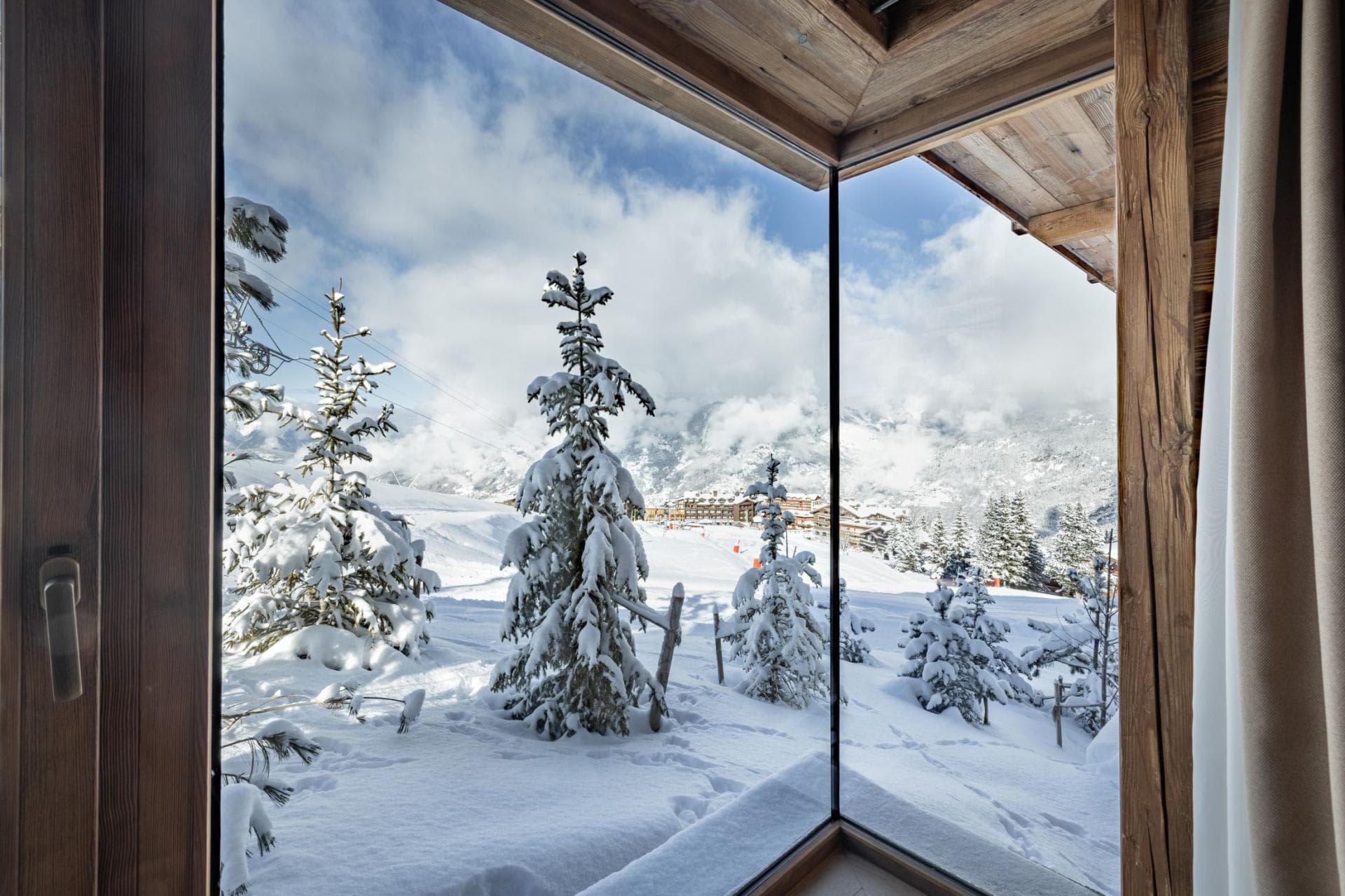 Floor-to-ceiling corner window with direct views of snow-covered ski slopes