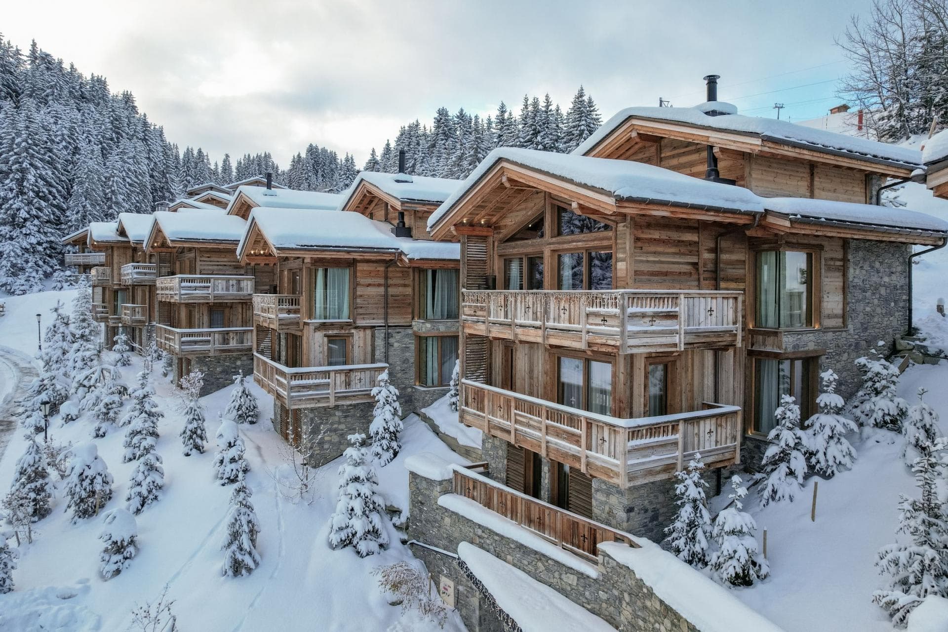 Ski-in/ski-out timber chalets with private balconies and mountain forest views