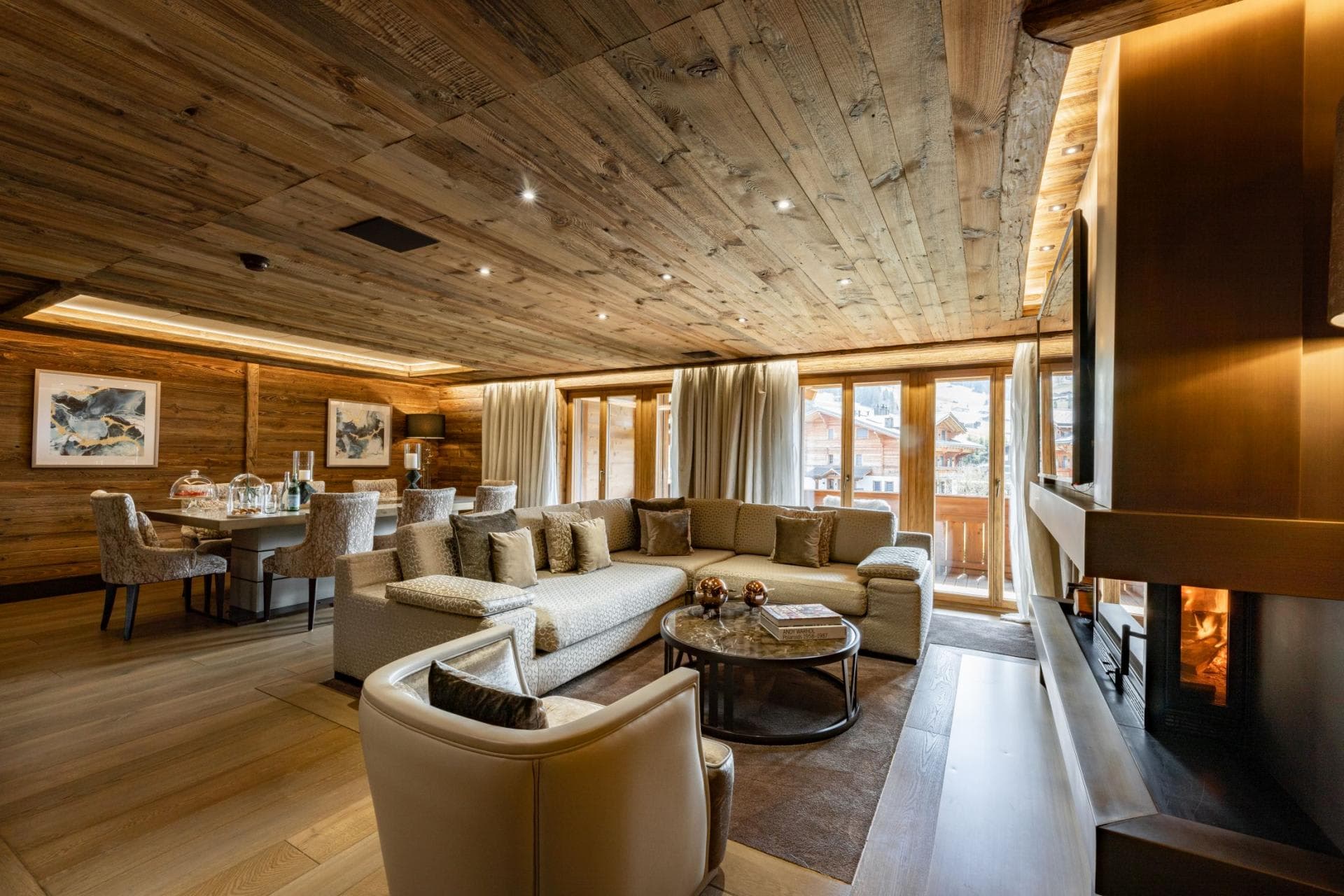Open living area with wood paneling, fireplace, and balcony access