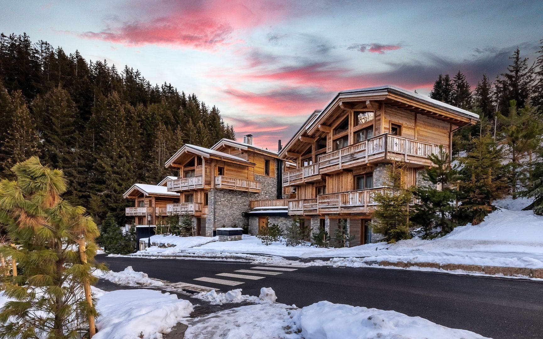 Ski-in, ski-out timber chalets with private balconies and forest backdrop