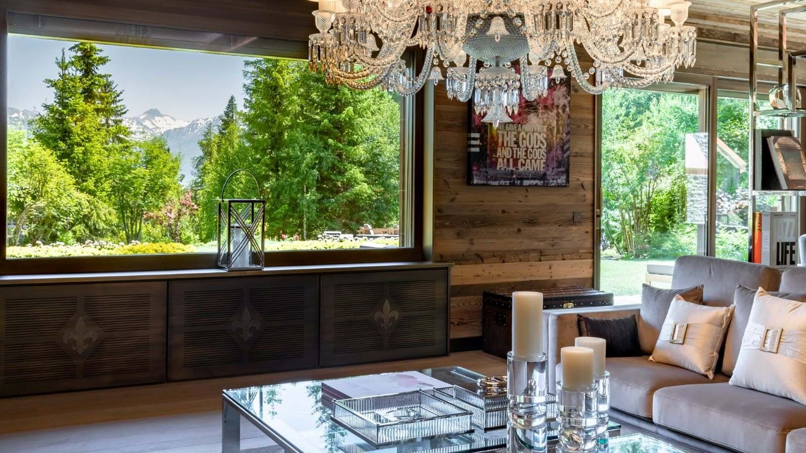 Living area with crystal chandelier and snow-capped mountain views