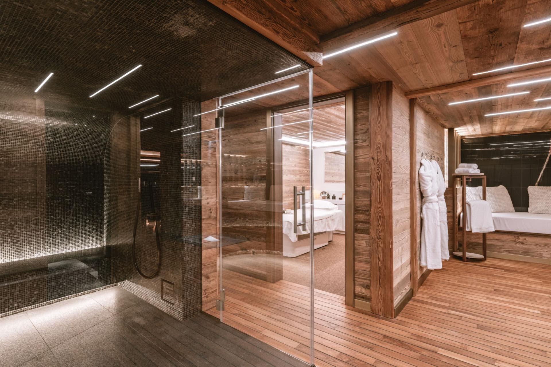 Private wellness suite with mosaic steam room and massage treatment room