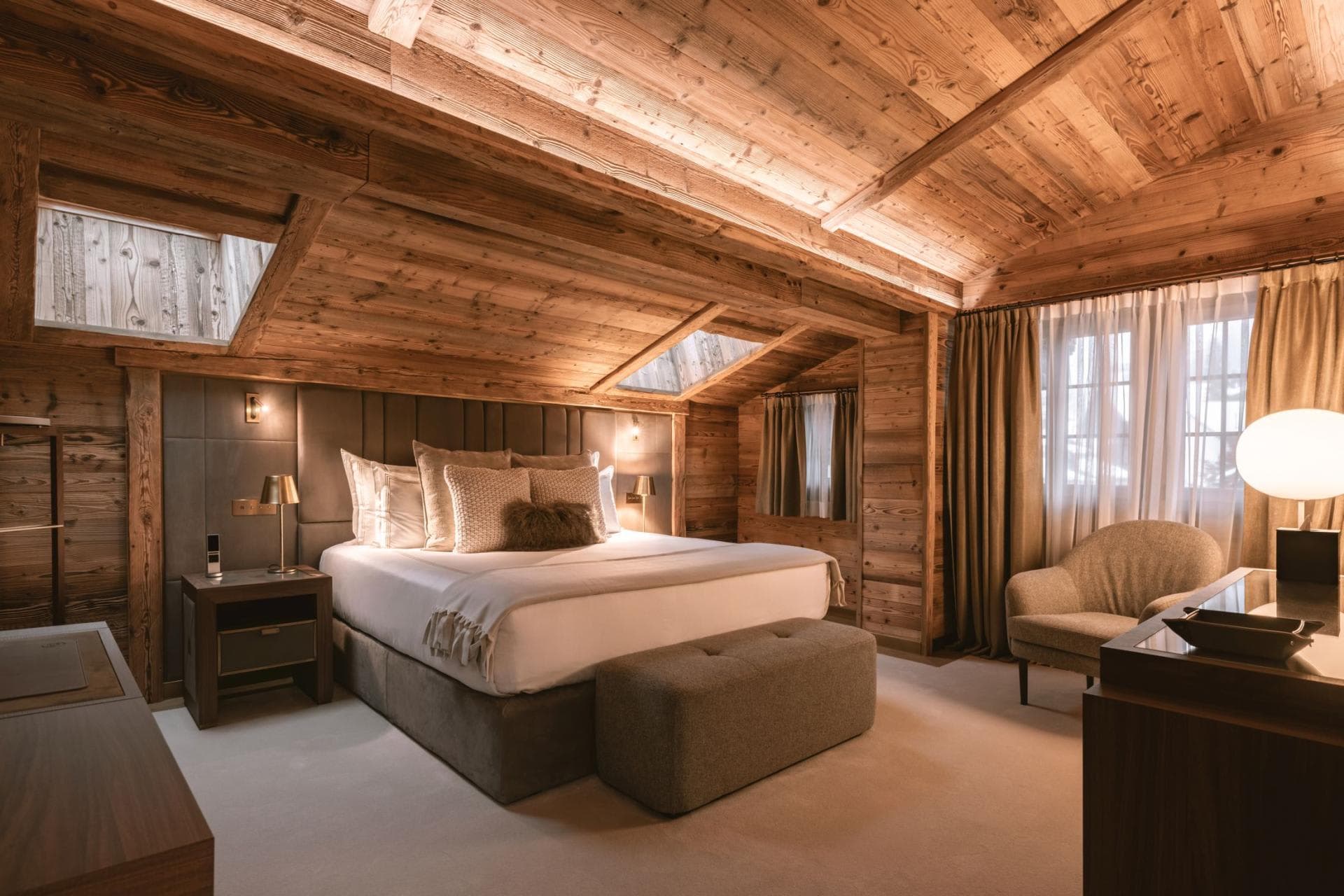King bedroom with wood-paneled walls and dual skylights