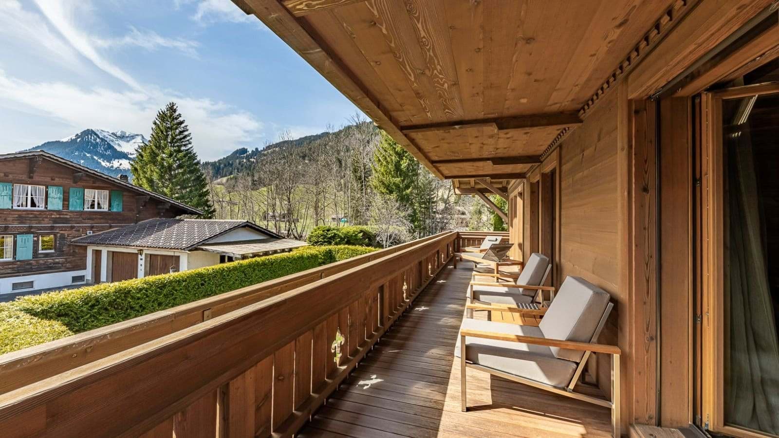 Covered wooden balcony with lounge seating for 4 and mountain views
