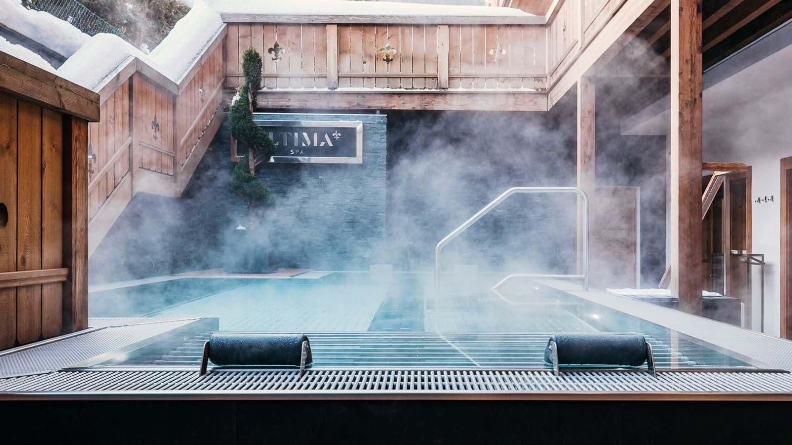 Outdoor heated pool with submerged seating and integrated headrests