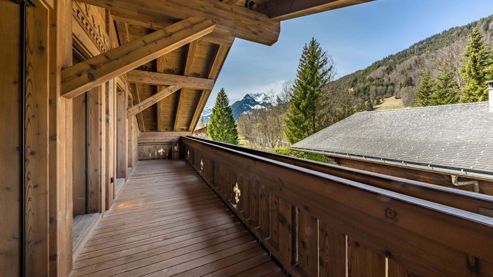 Covered wooden balcony with views of the surrounding mountains and valley