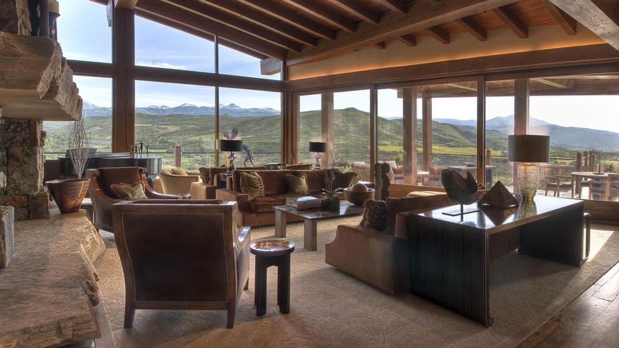 Living room with grand piano and floor-to-ceiling mountain views