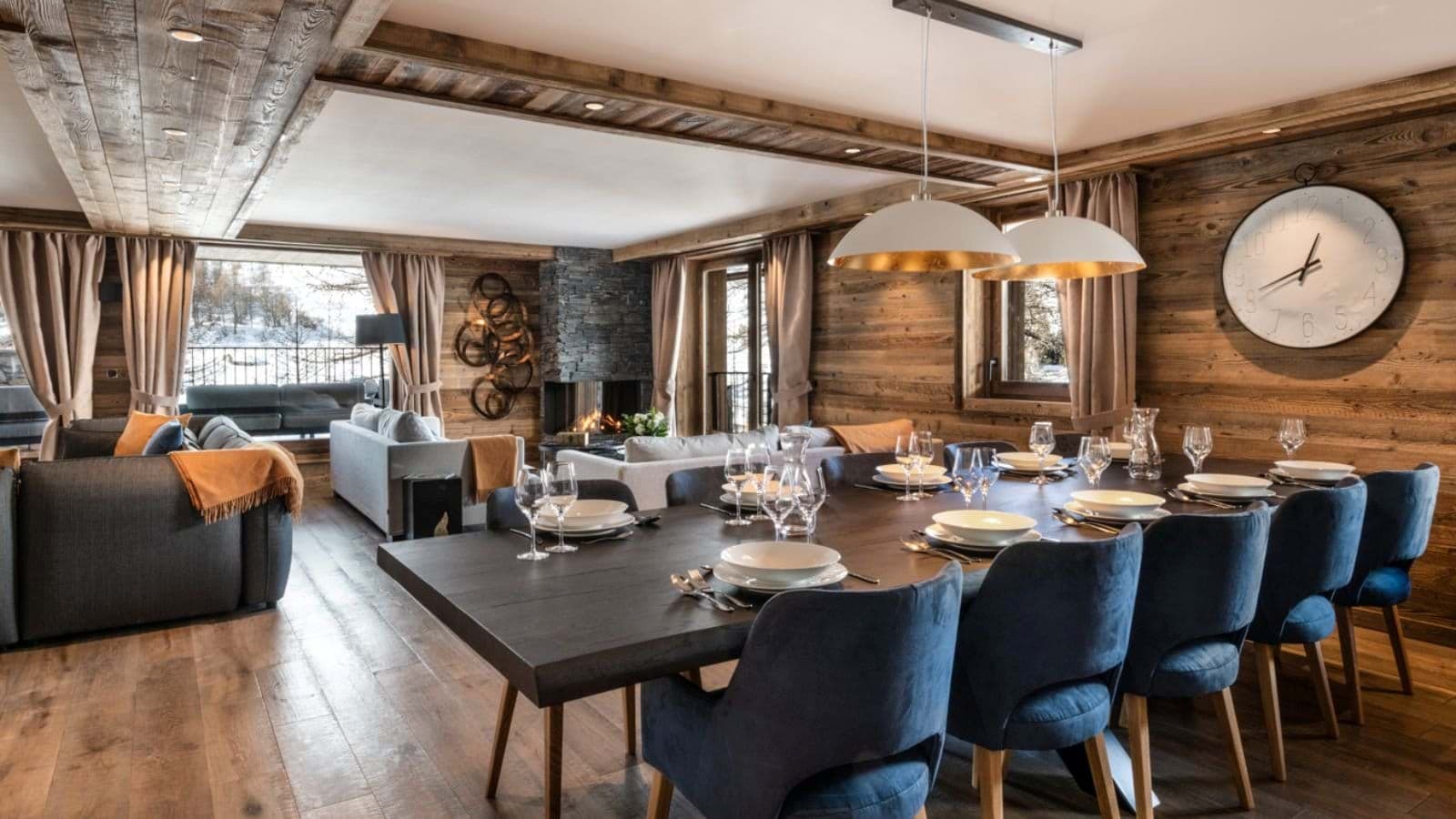 Dining table with seating for 10; adjacent living area with wood-burning fireplace