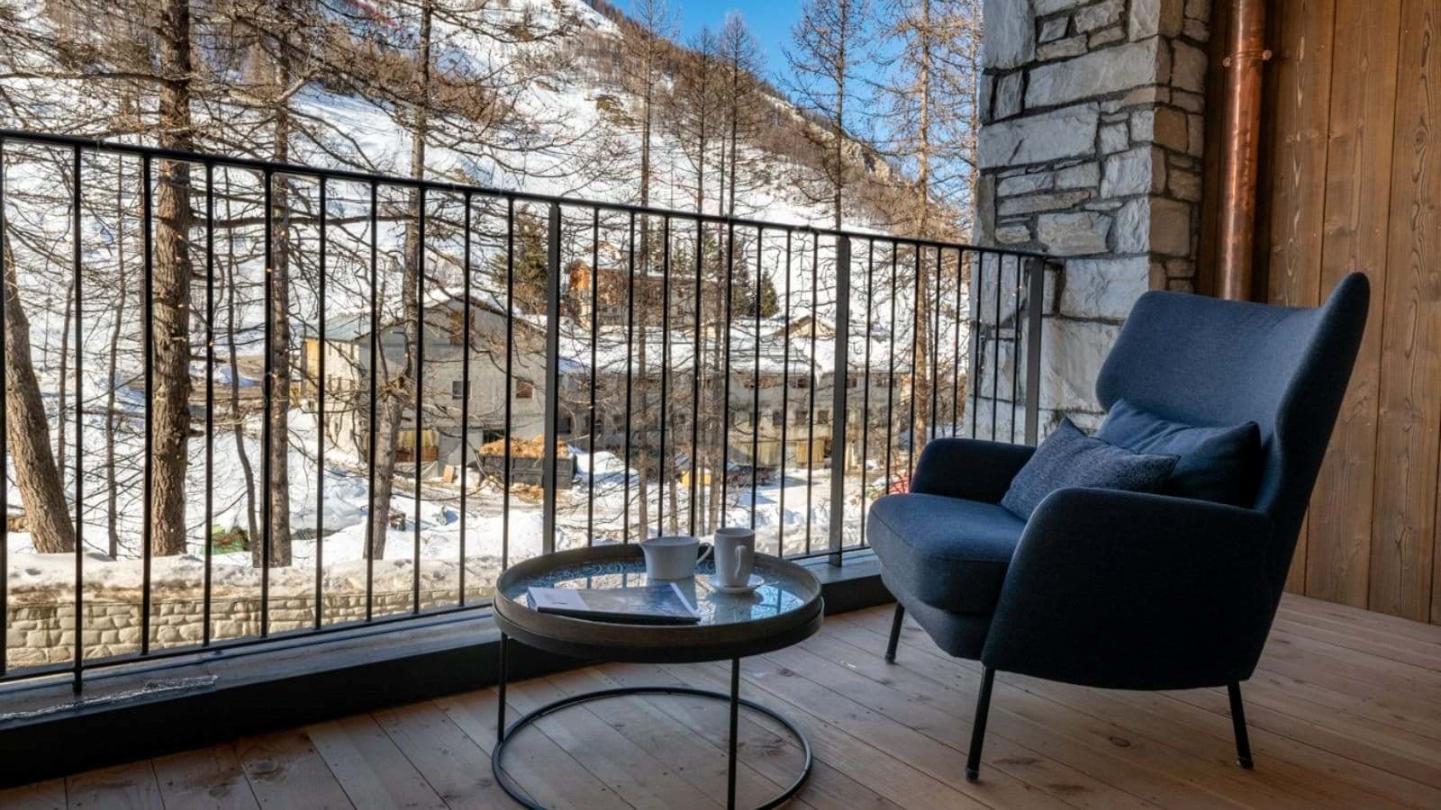 Private balcony with lounge seating and snow-covered mountain views