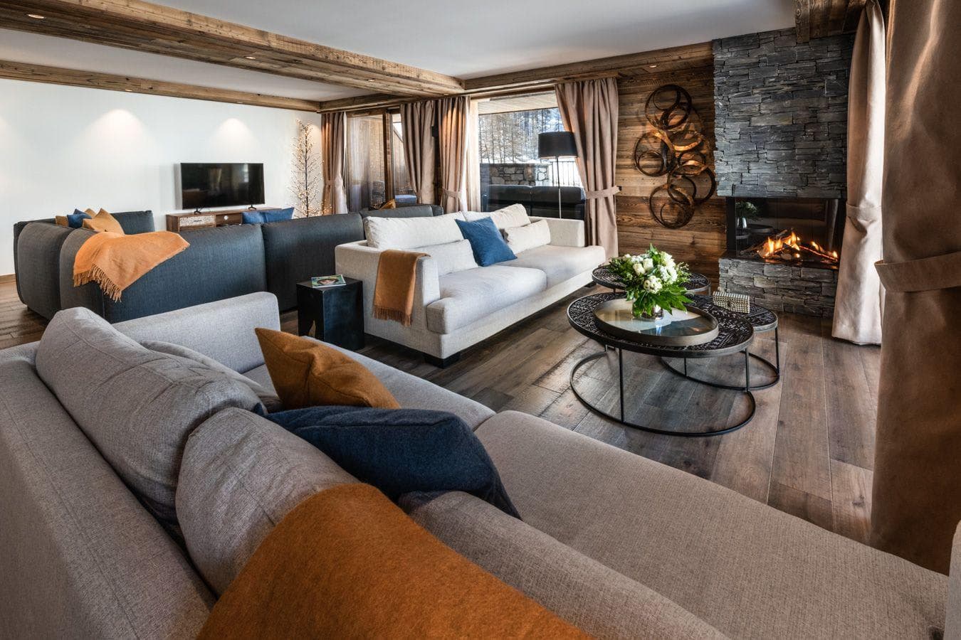 Living room with stone fireplace and seating for 10