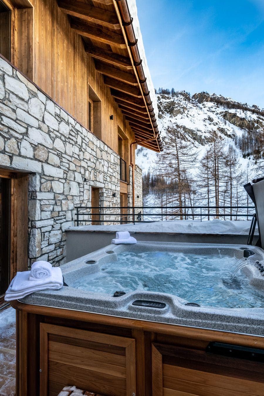 Outdoor hot tub on private terrace with mountain views