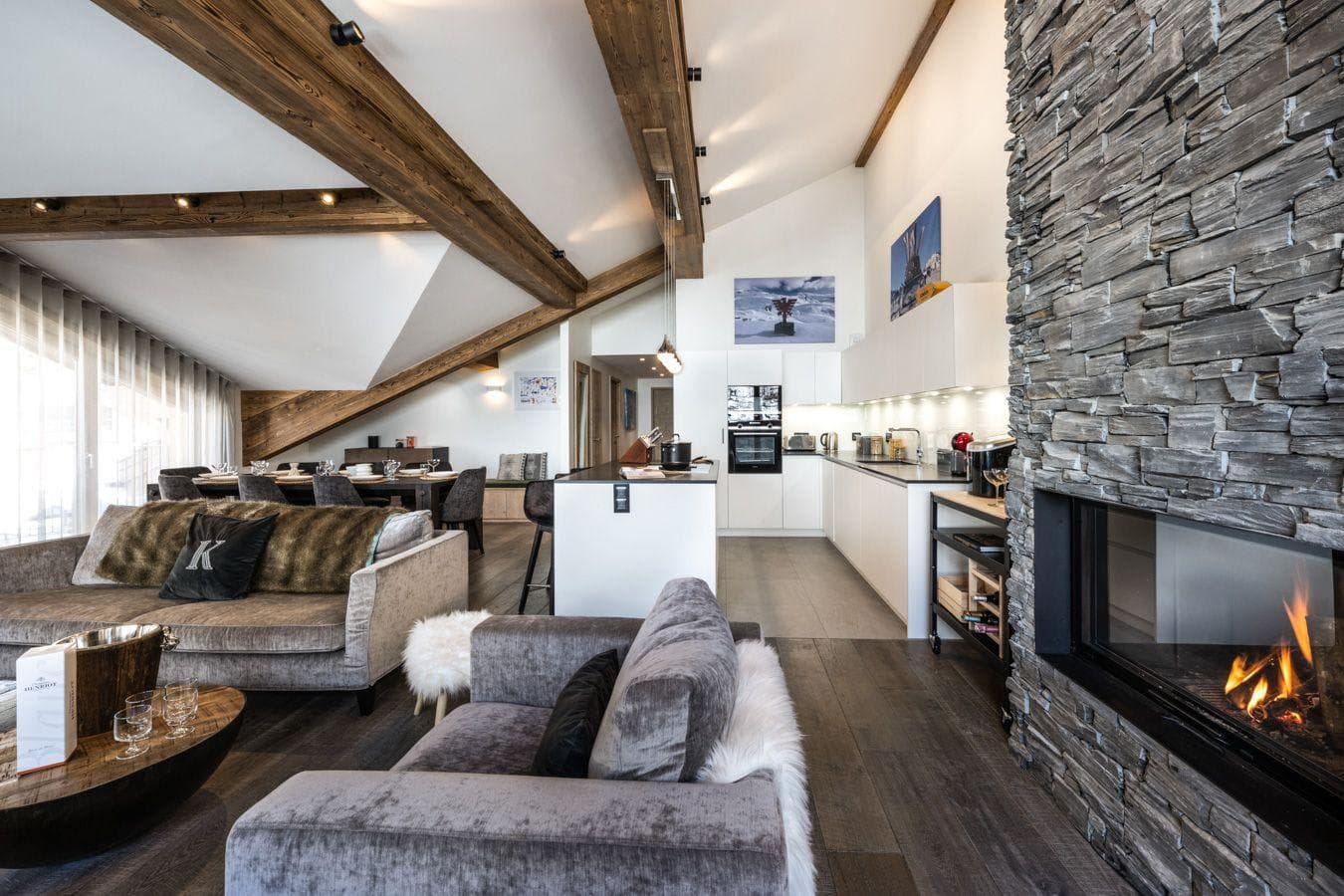 Open-plan living area with stone fireplace and vaulted timber ceilings
