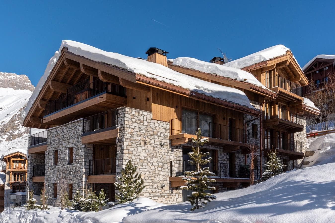 Ski-in chalet exterior featuring multiple private balconies and mountain views