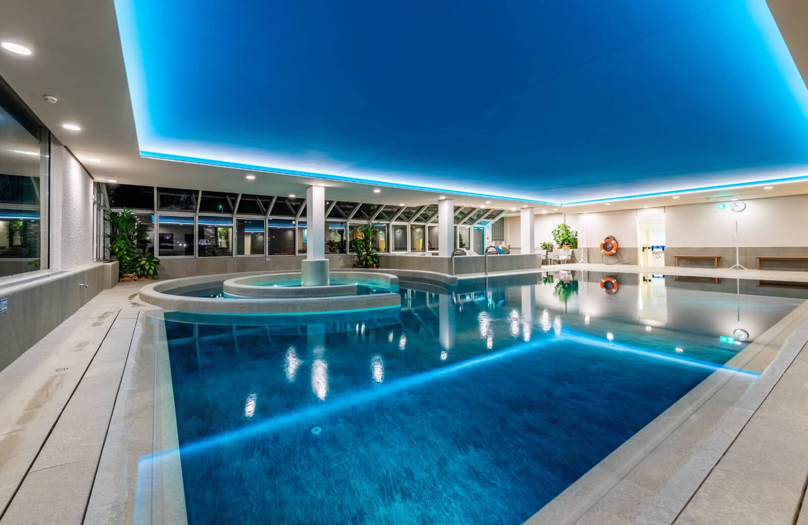 Indoor heated pool with integrated whirlpool and atmospheric cove lighting