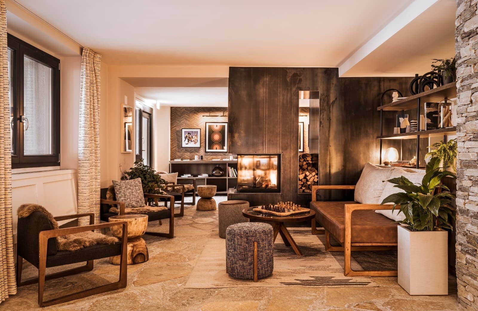 Lounge with wood-burning fireplace, flagstone flooring, and built-in chess table