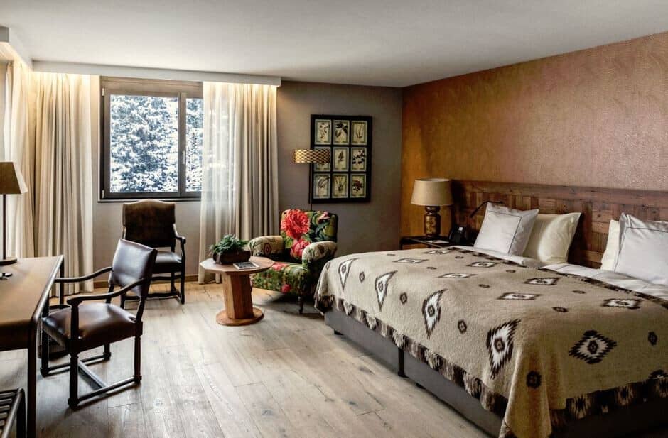 Bedroom with king bed and workspace; window overlooks snowy forest