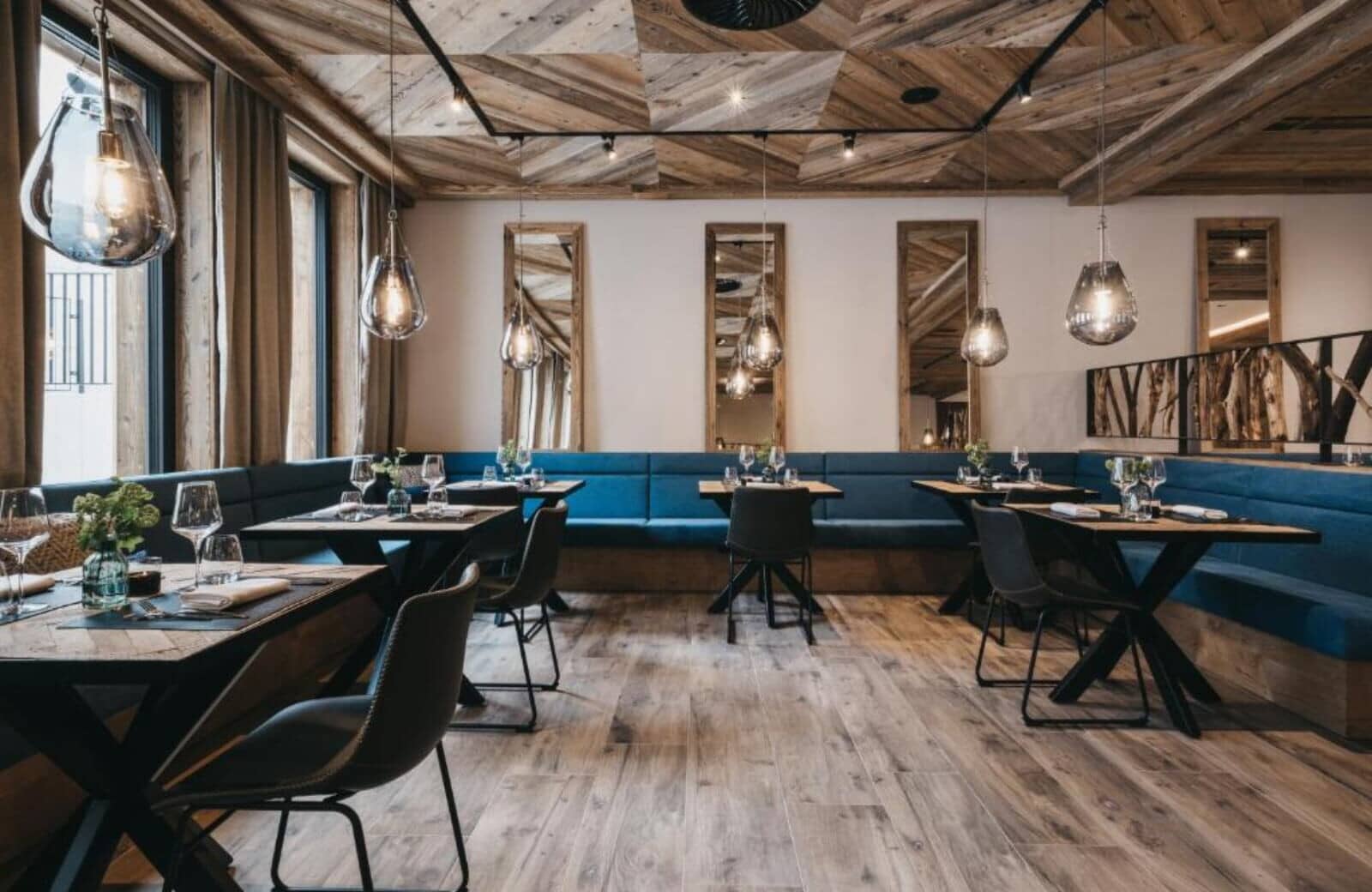 Dining area with banquette seating and geometric wood ceiling