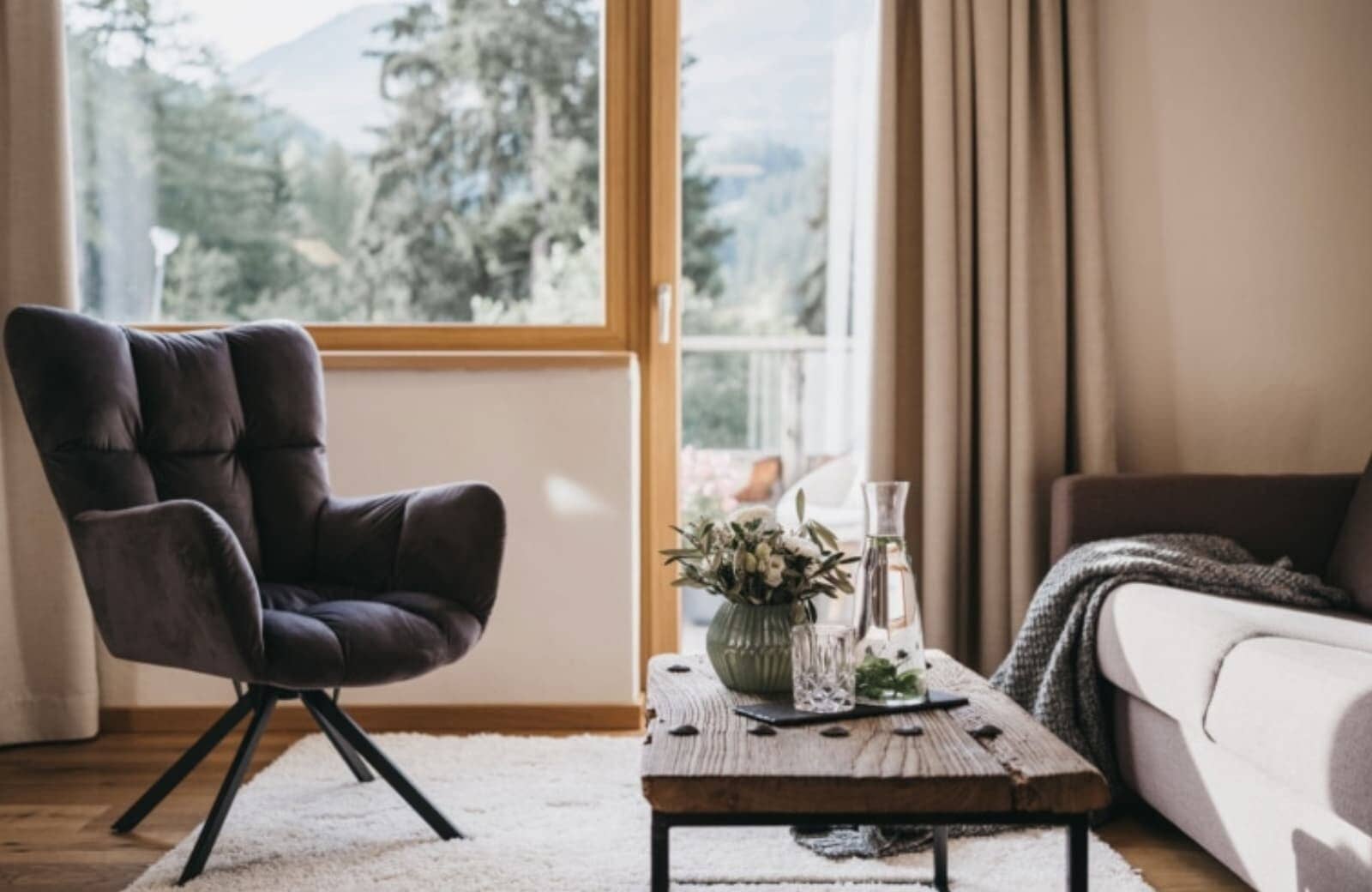 Living area with armchair and mountain views through balcony door