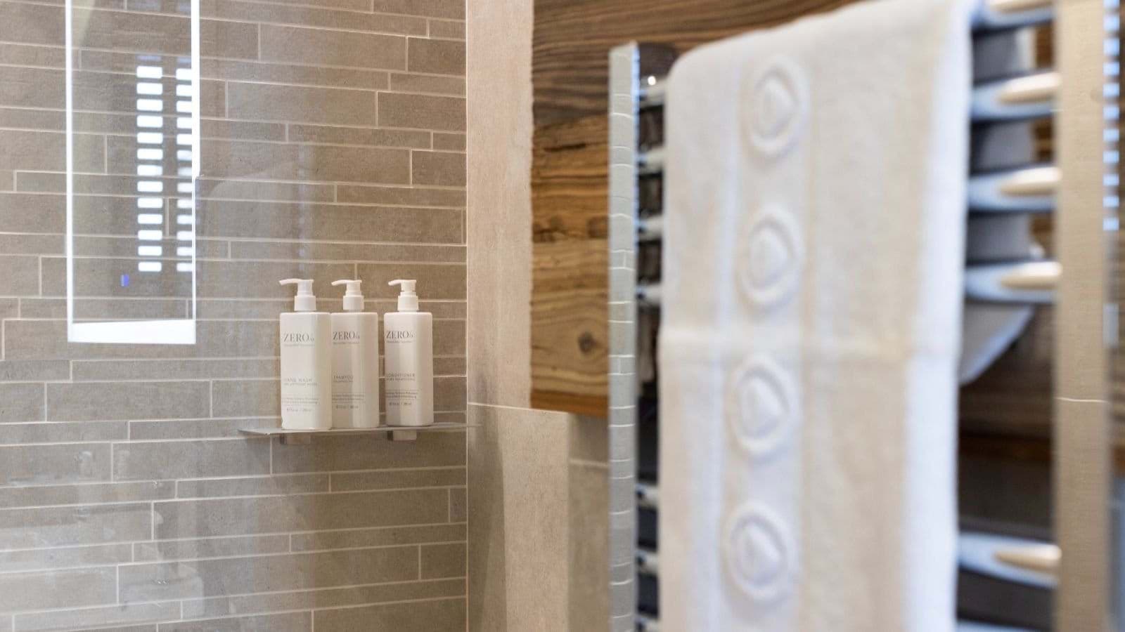 Walk-in shower with rainfall head, heated towel rail, and complimentary toiletries