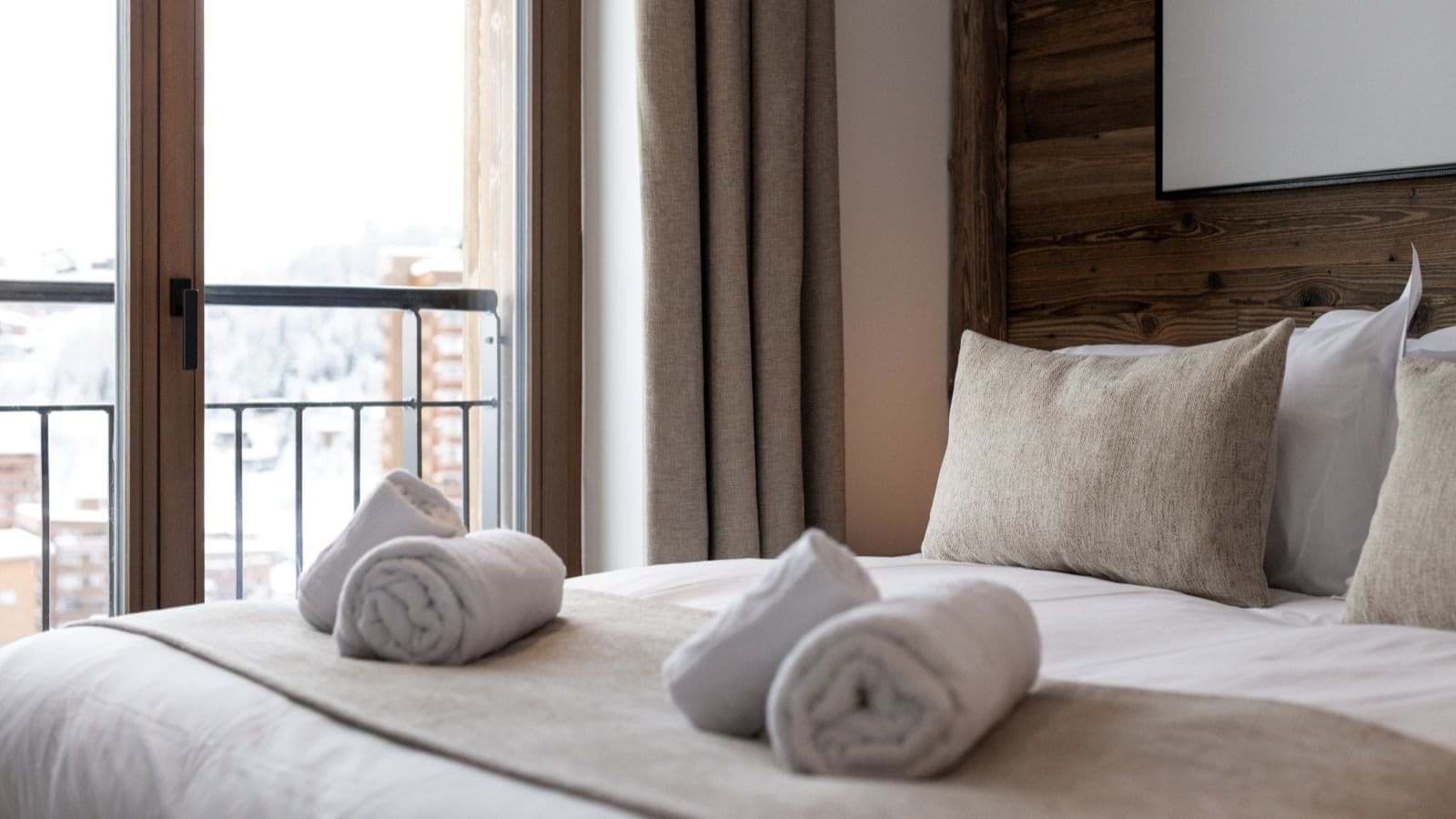 Bedroom with reclaimed wood headboard and Juliette balcony with alpine views