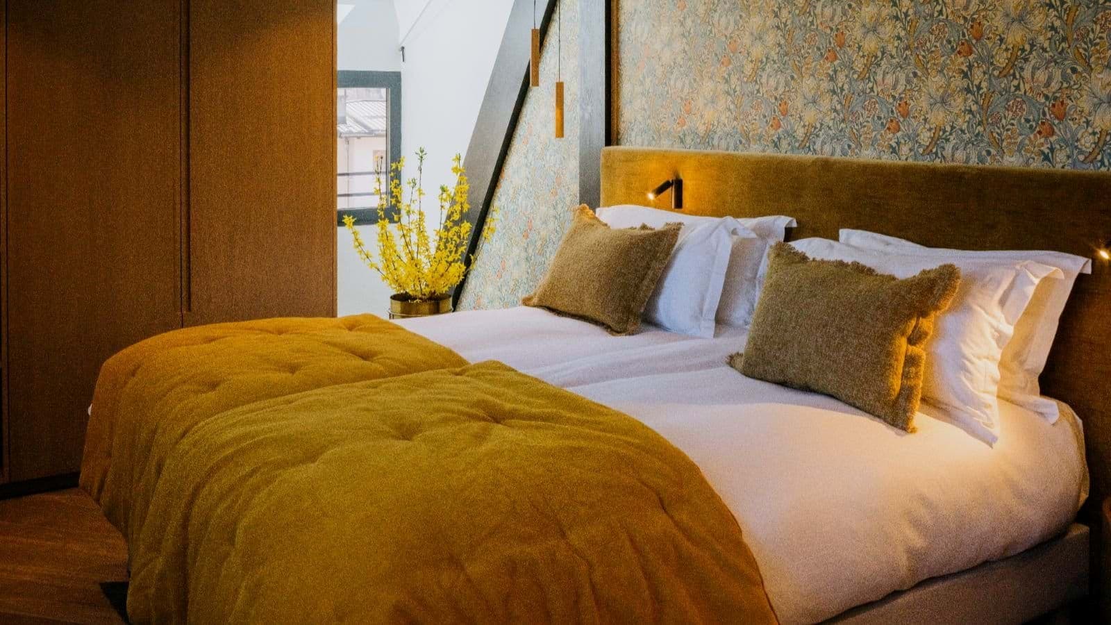 Bedroom with two twin beds pushed together and integrated reading lights