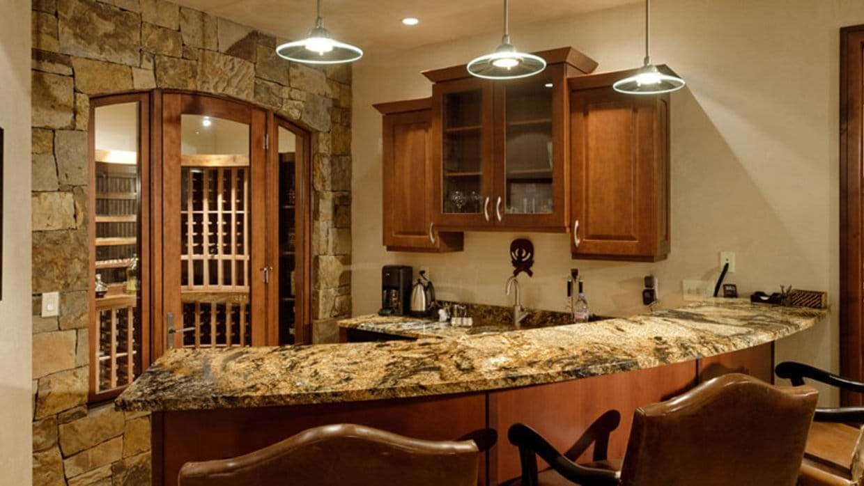 Lower-level wet bar with granite counters and adjacent wine cellar