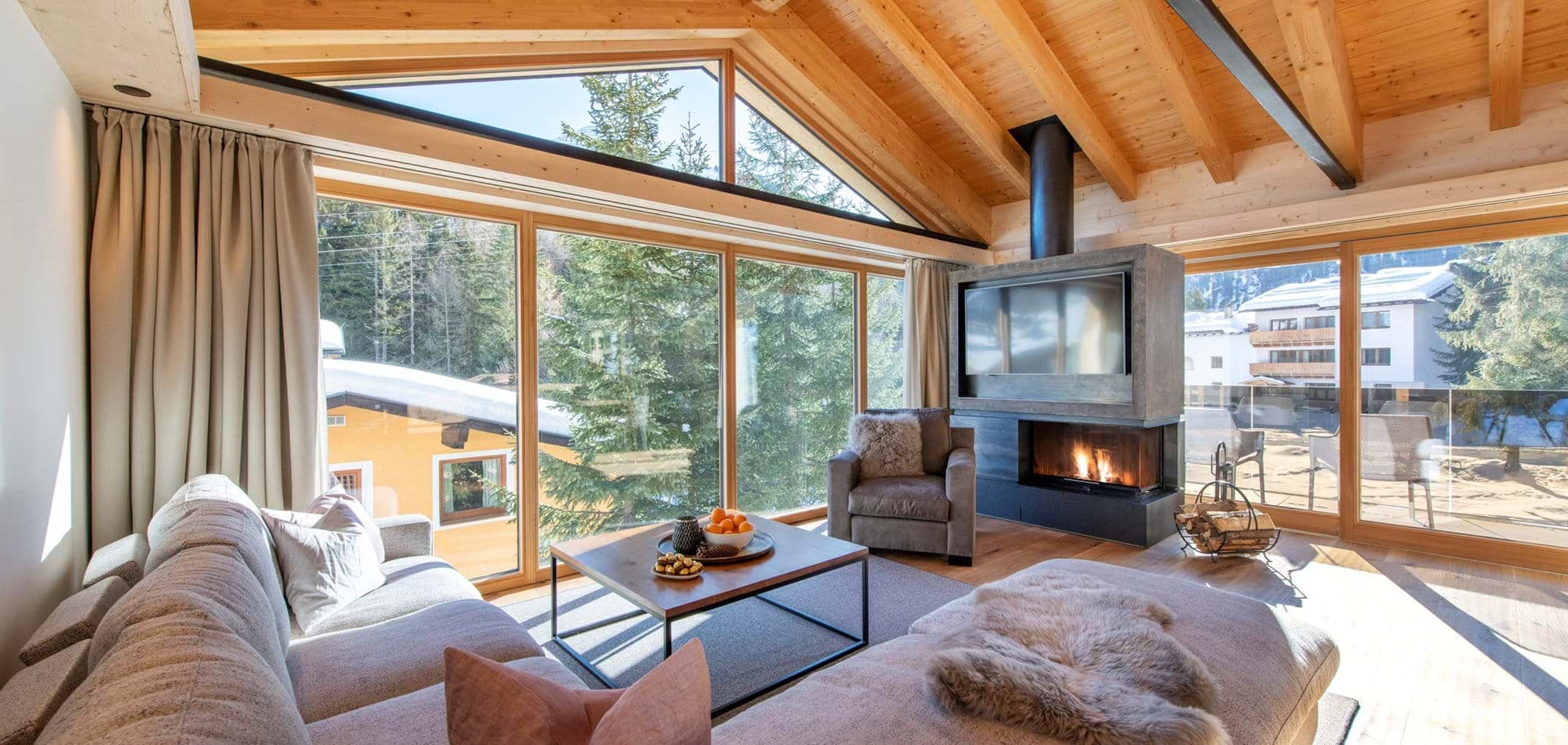 Living area with wood-burning fireplace and floor-to-ceiling mountain views