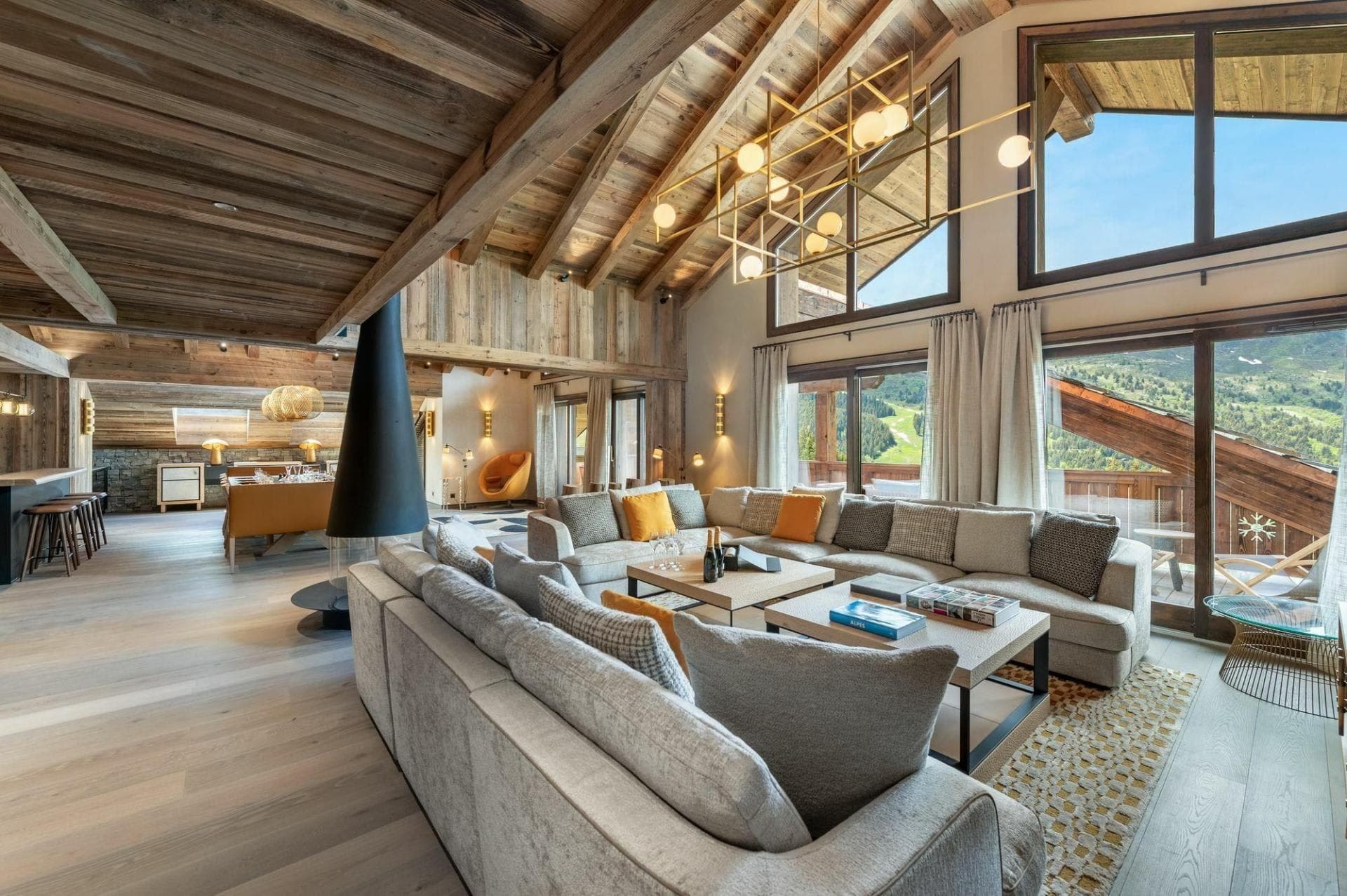 Open-plan living area with suspended fireplace and panoramic mountain views