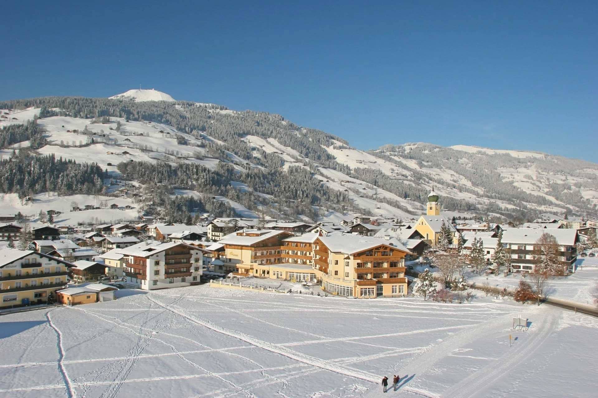 Ski village exterior with church tower and nearby groomed winter trails