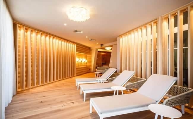 Spa relaxation room with heated loungers and wood slat walls