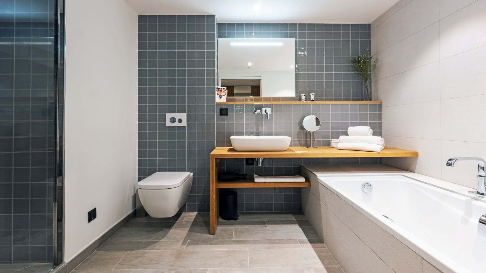 Master bathroom with heated floors, freestanding tub, and wooden vanity with vessel sink