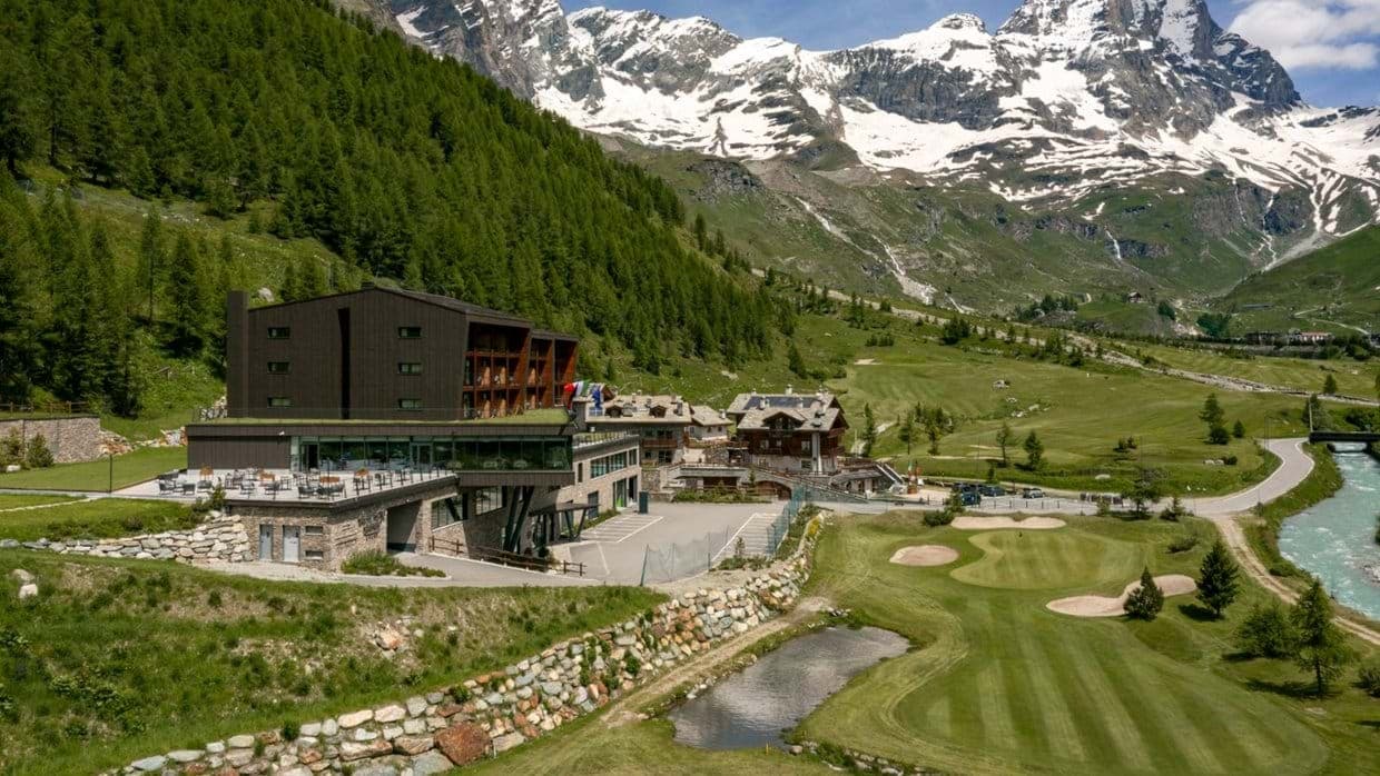 Resort exterior featuring on-site golf course and mountain backdrop