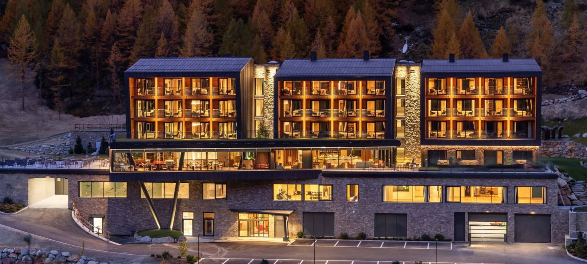 Property exterior with private guest balconies and forested mountain backdrop