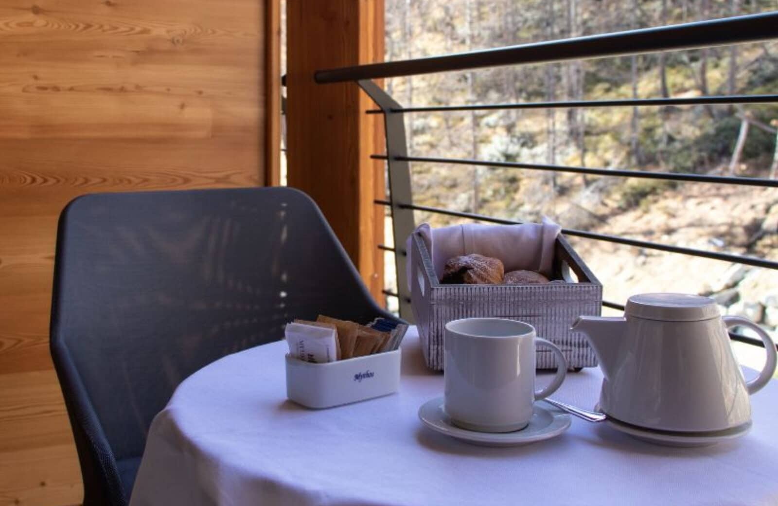 Private balcony with wood-paneled walls and forest views