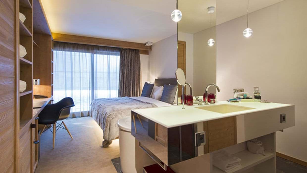 Open-concept primary suite with king bed, workspace, and ensuite vanity