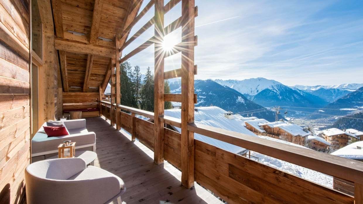 Covered balcony with lounge seating and panoramic mountain views