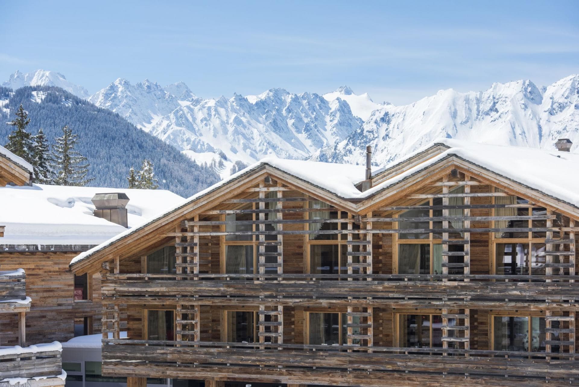 Timber chalet exterior with private balconies and panoramic alpine views