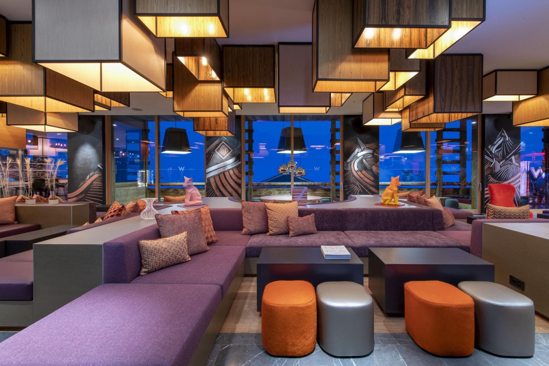 Shared lounge area with sectional seating and lantern-style ceiling installation