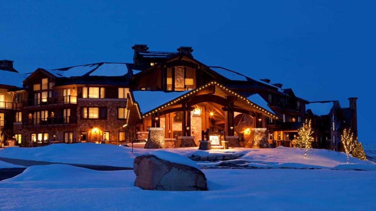 Ski-in, ski-out lodge exterior with illuminated porte-cochère entry