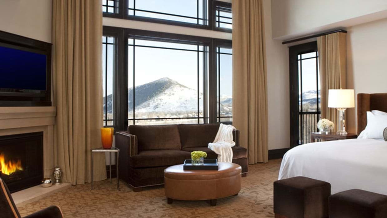 Primary bedroom with gas fireplace, king bed, and snow-capped mountain views