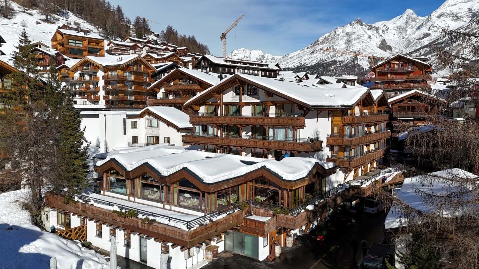 Chalet exterior with private balconies and snow-capped mountain backdrop