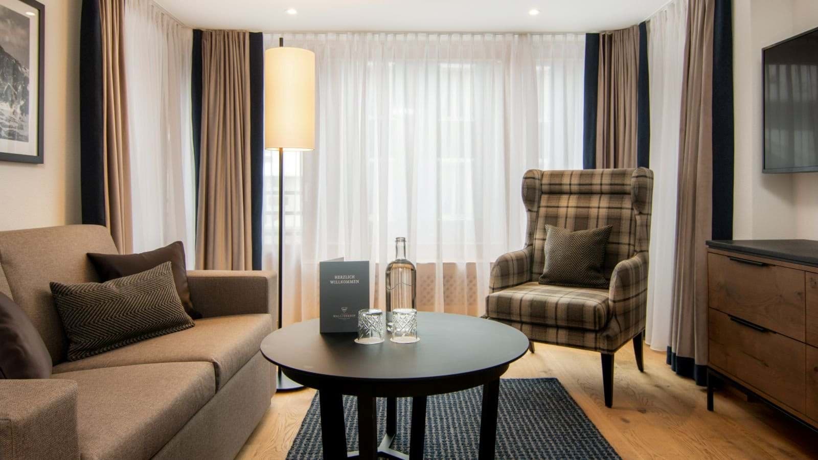 Seating area with sofa, wingback chair, and floor-to-ceiling blackout curtains